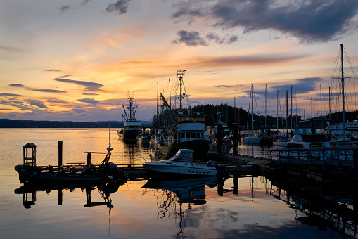 Fishing boats at sunset in Quathiaski Cove on Quadra Island in British Columbia, Canada.\nMay 16, 2022.
