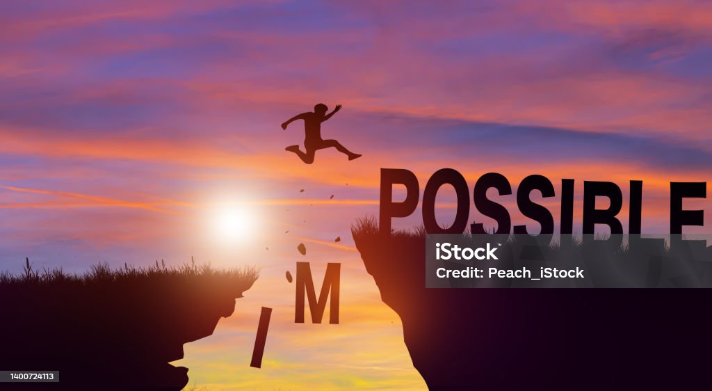 Silhouette man jumping over impossible and possible wording with cloud sky and sunrise. Positive mindset Concept. Silhouette man jumping over impossible and possible wording on cliffs with cloud sky and sunrise. Never give up, Success challenge, and Positive mindset Concept. Can Stock Photo
