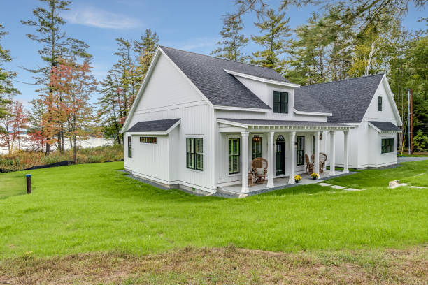 Modern farmhouse in a perfect setting with lots of trees and bright green grass