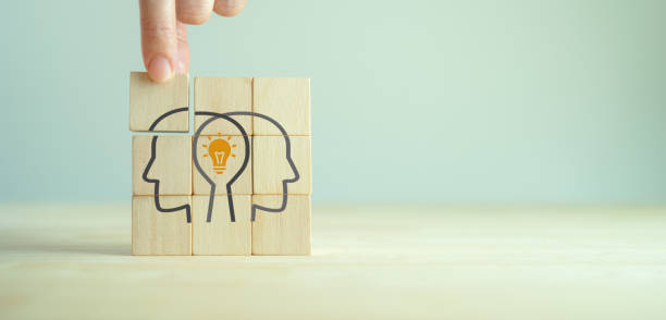 istock Knowledge and ideas sharing between two people head icon on wooden cube. Transferring knowledge, innovation, brainstorming concept. Business strategies to technology evolution reskill and new skill. 1400734503