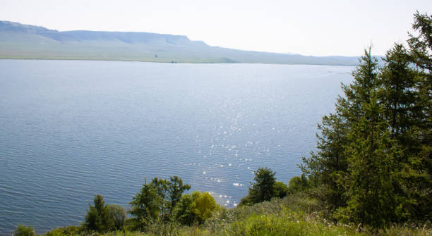 istock A large lake among trees and mountains on a summer day. 1400739289
