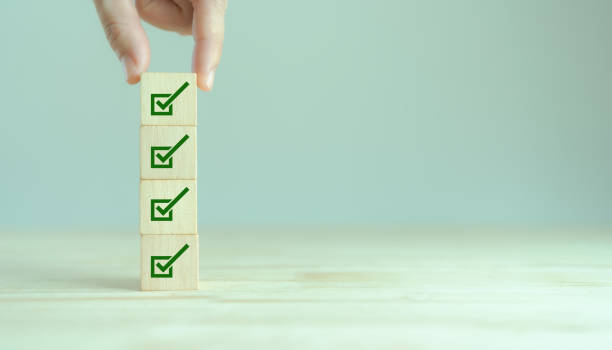 istock Corporate regulatory and compliance. Quality control management, ISO certification. Product, service quality warranty. Checklist survey and assessment  process. Put wooden cube with check mark icon. 1400743484