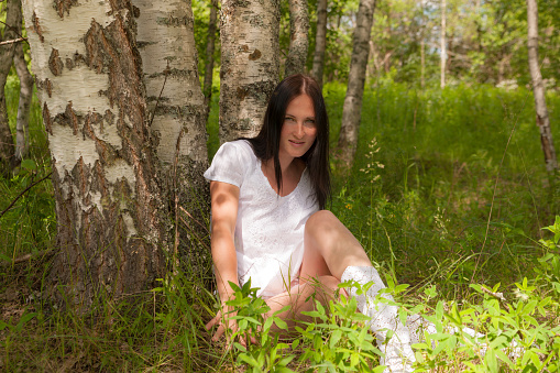 portrait of a girl in a white dress in a summer forest