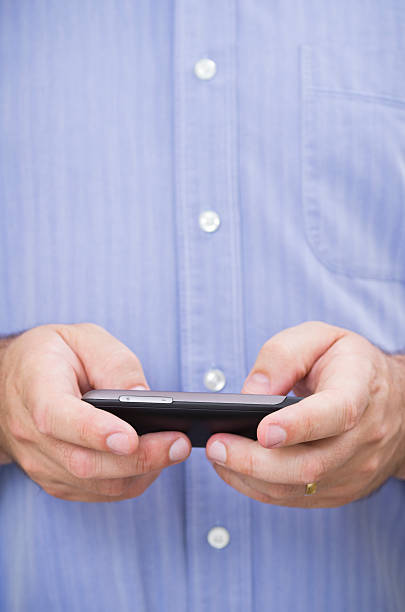 istock Casual businessman types a message on his touchscreen smartphone 140074707