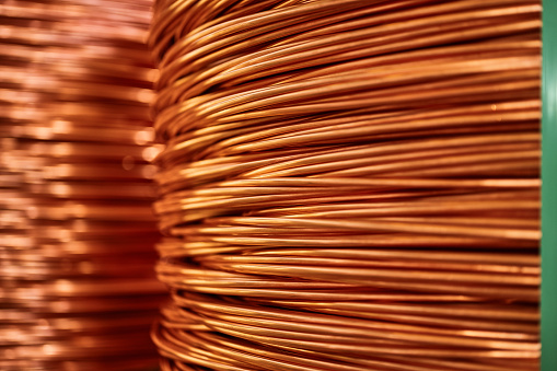 Shiny colorful winded thick copper cable at bright light in warehouse of contemporary equipment production plant extreme closeup