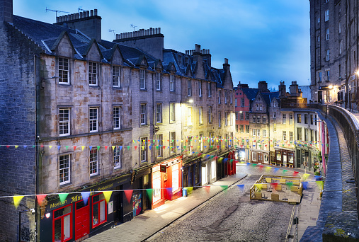 Edinburgh, UK - Mai 13, 2022: victoria street at night, built between 1829-34 as part of a series of improvements to the Old Town, with the aim of improving access around the city