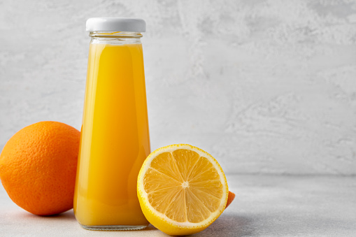 Orange fruit and orange juice on wooden background, close up
