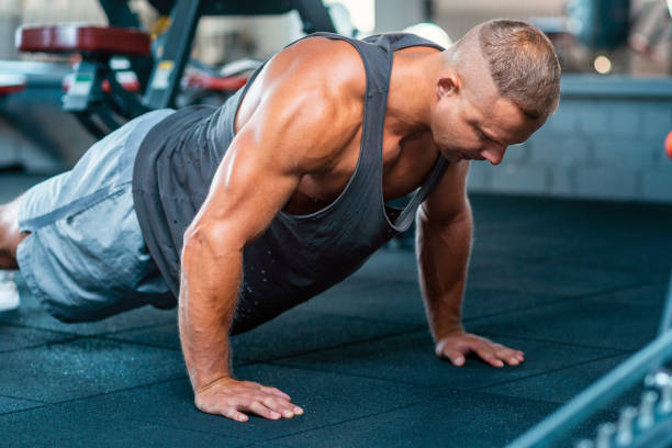 istock Muscular man doing push up exercise workout in the gym.Close up. 1400753685