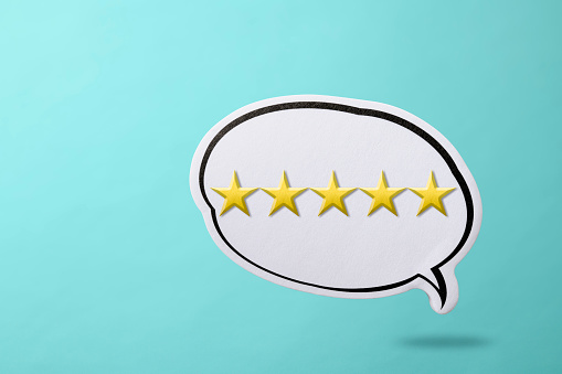 Golden five star in speech bubble floating in mid-air against light blue background. Quality, review, Best Excellent Services Rating for Satisfaction.