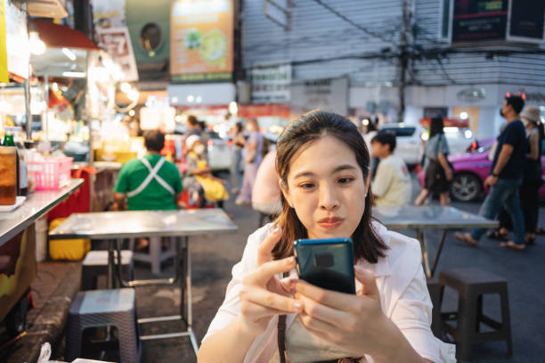 istock Working life modern genration z relaxing after work meeting with friend appointment using smart phone at night market with office building office background in bangkok thailand 1400755910