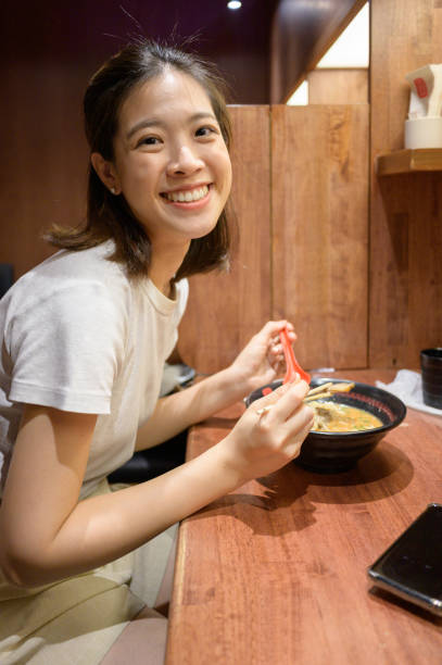 istock Asian female eating ramen in restaurant 1400756516