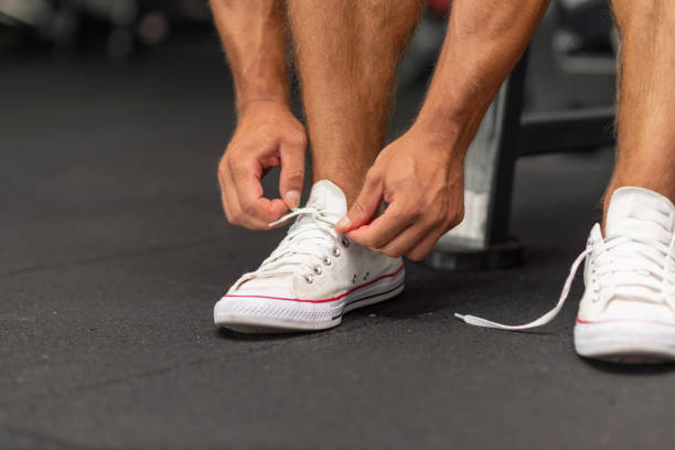 istock Sport man tying his shoelaces before a workout in a gym.Cropped image. 1400756685