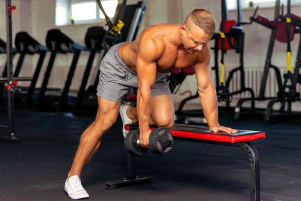 istock Strongman bodybuilder exercising with dumbbell in a modern gym.Copy space. 1400757843
