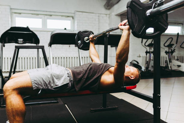 istock Bench Press Exercise.athletic man pumping up muscles on bench press at the gym. 1400758064