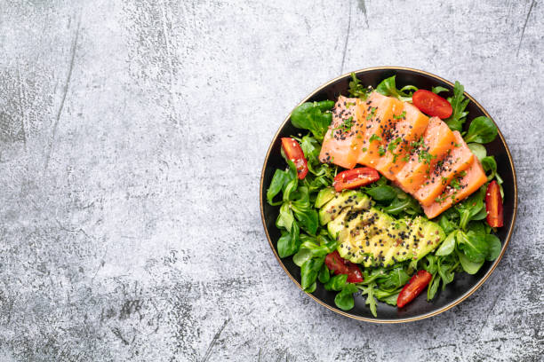 istock Salmon fish fillet with fresh salad, avocado top view. 1400761762