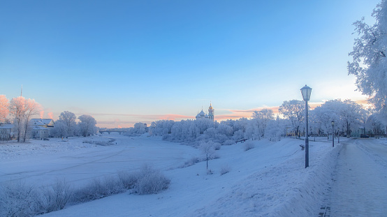 View of the frozen river and the city Kremlin - The gilded dome of the bell tower and the domes of St. Sophia Cathedral