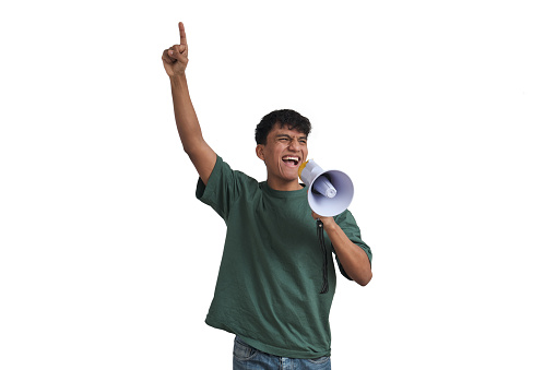 Angry senior male screaming into megaphone while standing against white background