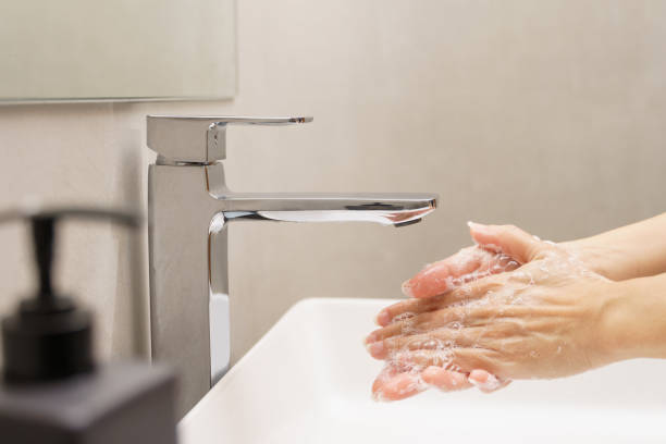 крупный план женской стирки рук и потирания рук пузырьками в современной дизайнерской ванной комнате - sustainable resources water conservation water faucet стоковые фото и изображения