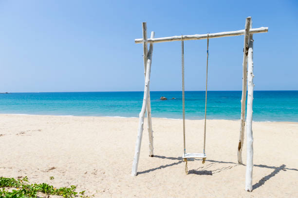 istock Wooden swing on peaceful beach background 1400763315