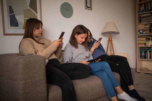 istock Sisters indoors using their smart phones 1400764522