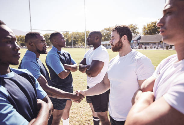 istock Two opponent rugby teams shaking hands before or after a match outside on a field. Rugby players sharing a handshake to show respect and sportsmanship. A mutual understanding for the game to be played 1400766256
