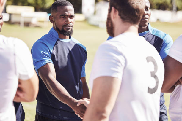 istock Two opponent rugby teams shaking hands before or after a match outside on a field. Rugby players sharing a handshake to show respect and sportsmanship. A mutual understanding for the game to be played 1400766269