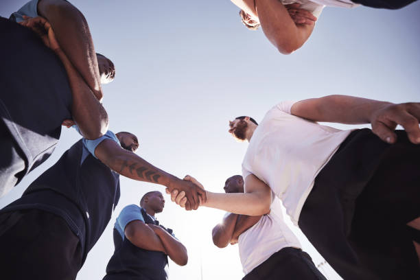 istock Below two opponent rugby teams shaking hands before or after a match outside on a field. Rugby players sharing a handshake to show respect and sportsmanship. A mutual understanding of the game 1400766906