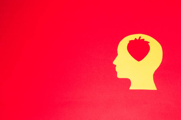 yellow head with strawberry in it, red background with copy space, creative art design, summer minimal concept, smart head