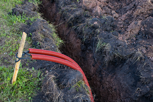 Laying communications in the ground. Red electric cable