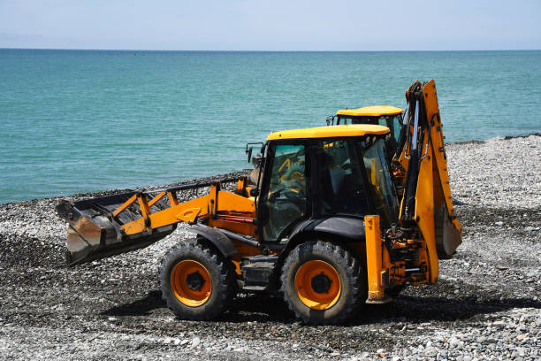 istock Two excavators with a wheel loader levels the sea coast. 1400775273