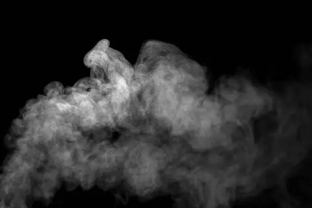 Photo of Close-up of fog or smoke white steam effect With visible water droplets, abstract floating on top. isolated on a black background