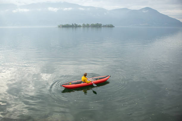 istock Man canoeing on a lake, early morning 1400778499