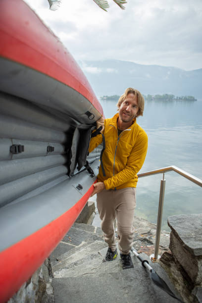 istock Man holding red canoe, getting ready to enter the water 1400778645