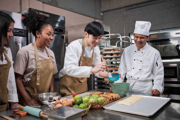 istock Senior chef teaches cooking students to prepare pastry dough for fruit pies. 1400779708