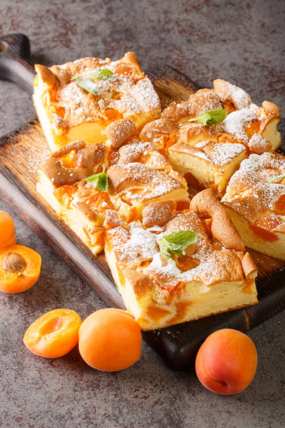 istock Sponge cake with apricots, dusted with icing sugar closeup on the wooden board. Vertical 1400780731
