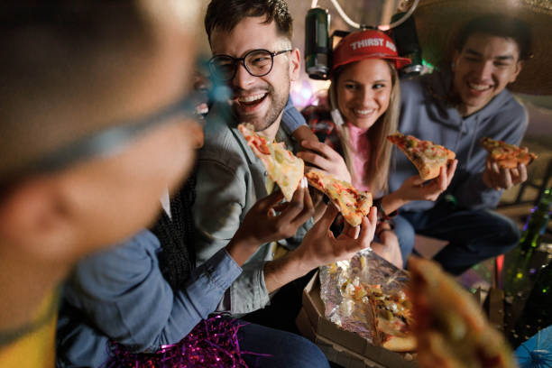 istock Happy friends talking while eating pizza for dinner on a party at home. 1400784075