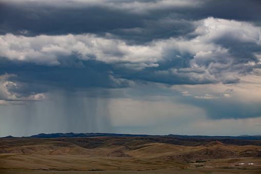 Storm clouds and rain over the mountains panoramic view. Kazakhstan, Almaty province.