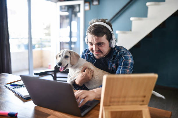 istock Concentrated Freelancer Holding Dog In Lap While Checking Task List And Listening To Music From Home 1400789710