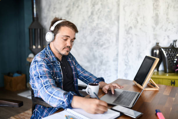 istock Dwarf Male Writing Down Project Ideas While Enjoying Coffee, Music And Working From Home 1400790747
