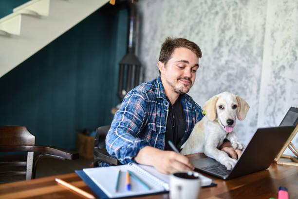 istock Dog Making Stress Free Atmosphere For Owner With Dwarfism Disability While He Works From Home 1400790803