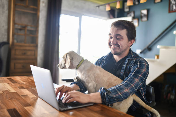 istock Cute Puppy Trying To Get Attention From Owner With Dwarfism While He Works From Home 1400790862