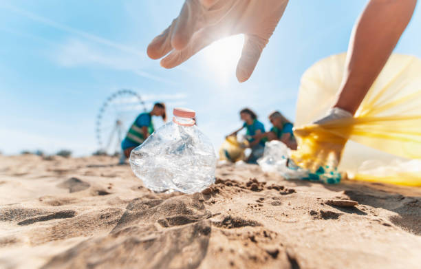 gruppo di eco volontari che raccolgono rifiuti di plastica sulla spiaggia - attivisti che raccolgono rifiuti per proteggere il pianeta - inquinamento degli oceani, conservazione ambientale ed ecologia - trash day foto e immagini stock