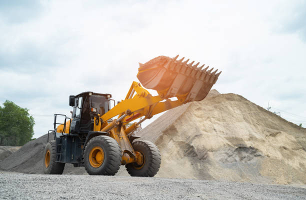 istock Sand loaders are shoveling rocks into dump trucks. 1400793984