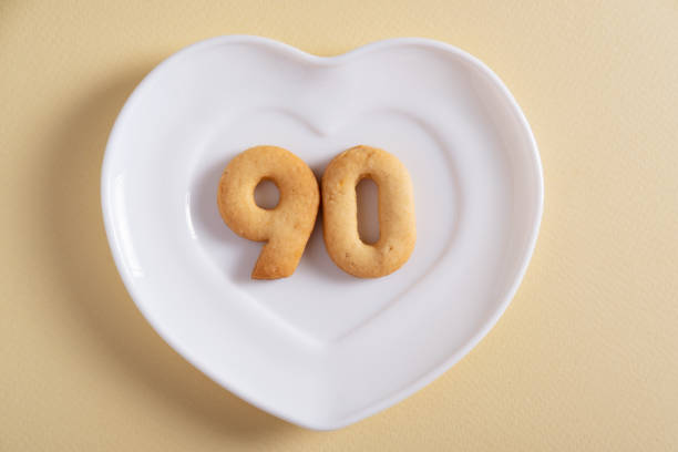 istock Biscuits forming number 90 on the white plate and yellow light background 1400794239