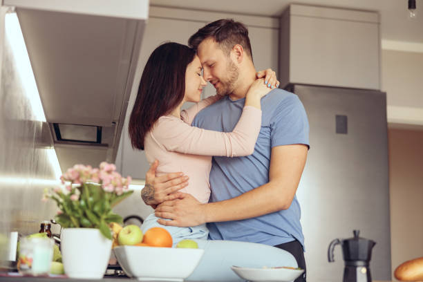 Portrait of couple in love embracing at home interior. man and woman hugging in kitchen. Portrait of couple in love embracing at home interior. man and woman hugging in kitchen. Together. trophy wife stock pictures, royalty-free photos & images