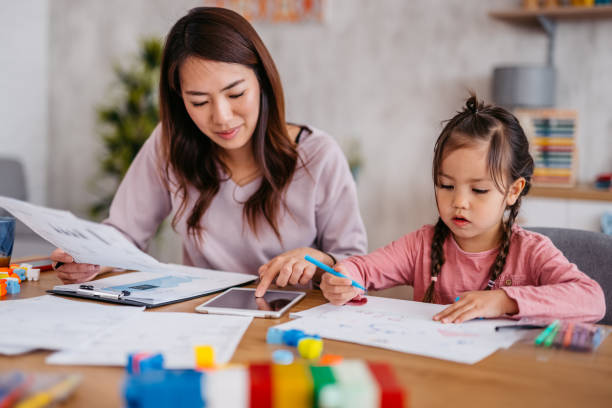 istock Young Mother Checking Her Finances While Her Daughter Is Playing Next To Her 1400796093