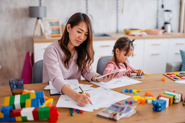 istock Young Mother Checking Her Finances While Her Daughter Is Playing Next To Her 1400796132