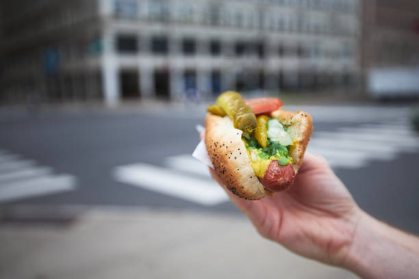 Close-up of hand holding hot dog. Street food in Chicago.\