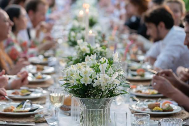 뒷마당에있는 결혼식 리셉션 테이블에서 저녁 식사를하는 사람들의 그룹. - wedding reception fine dining table restaurant 뉴스 사진 이미지