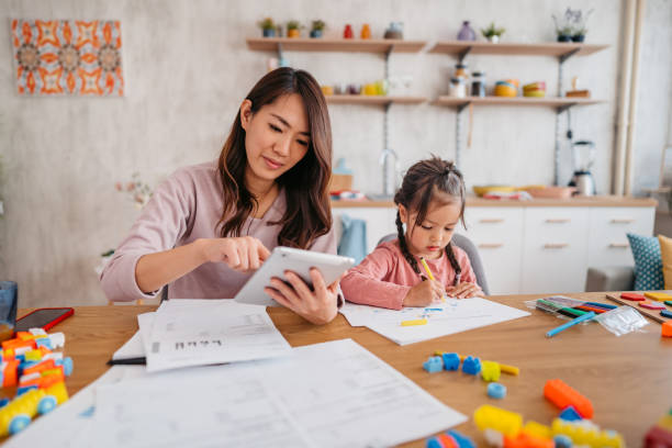 istock Young Mother Checking Her Finances While Her Daughter Is Playing Next To Her 1400796348